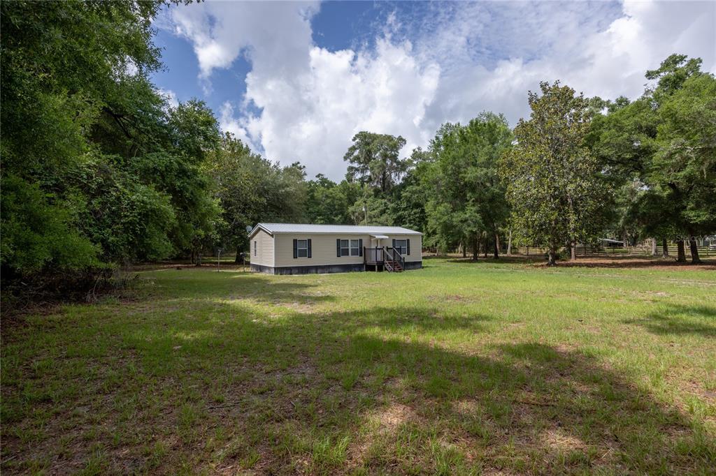 4950 80 Street Chiefland, FL 32626 - Photo 5 of 68 a front view of a house with a yard and trees