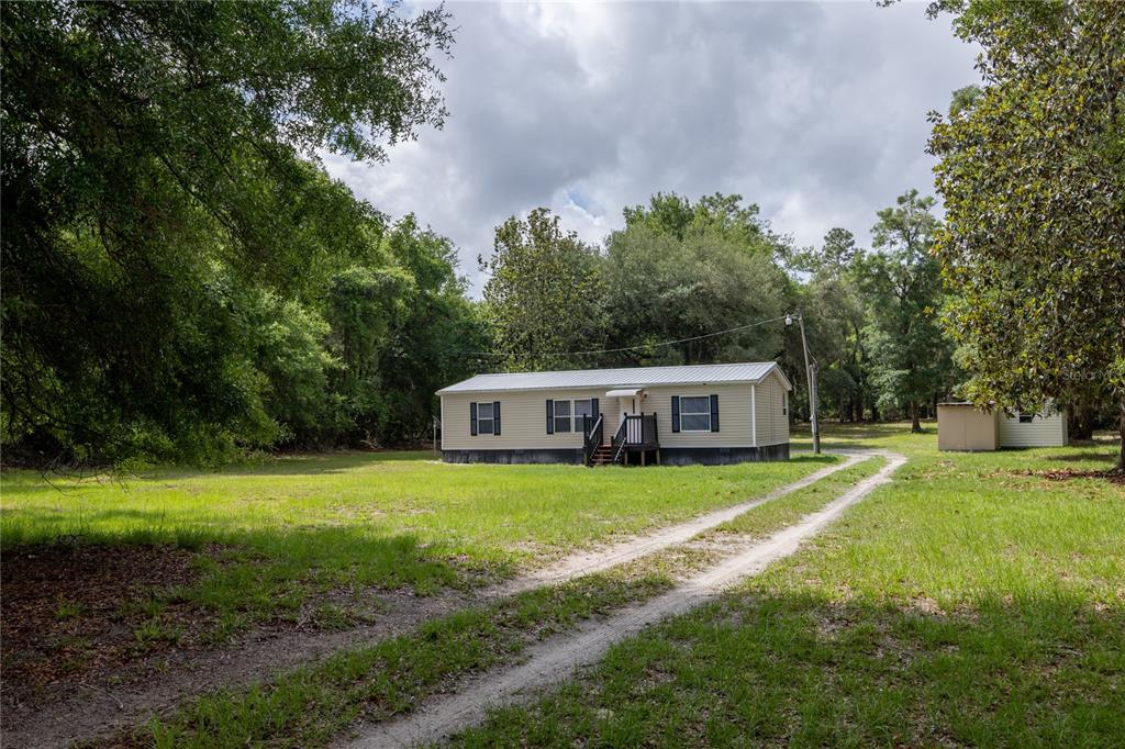 4950 80 Street Chiefland, FL 32626 - Photo 6 of 68 a front view of a house with a yard and trees