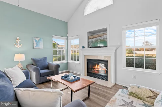 a dining room with wooden floor a chandelier a wooden table and chairs