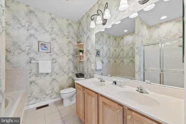 a bathroom with a sink vanity mirror and toilet