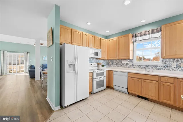a large kitchen with stainless steel appliances granite countertop a refrigerator and a sink