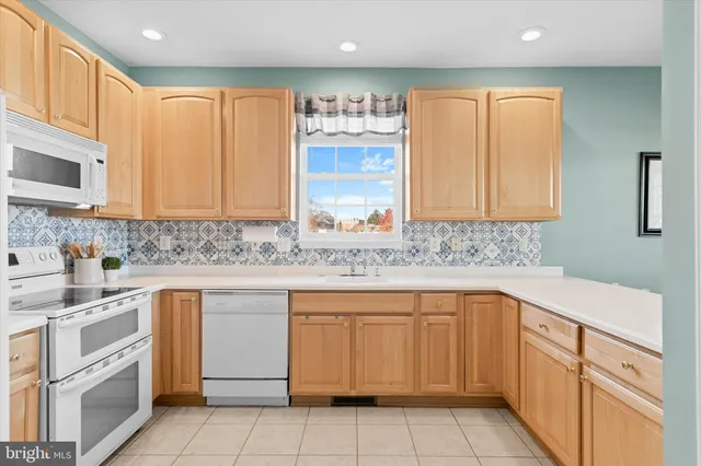 a room with white cabinets and chandelier