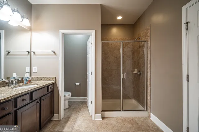 a bathroom with a shower a sink a toilet and shower