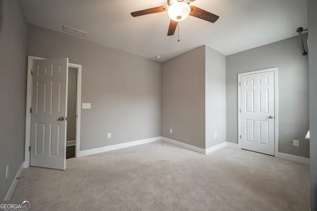 a view of an empty room with a chandelier fan