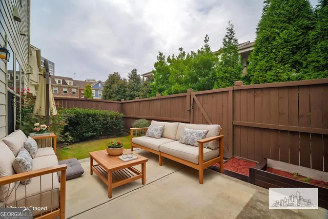 a backyard of a house with fountain table and chairs