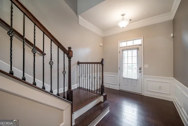 a view of staircase with railing and white walls