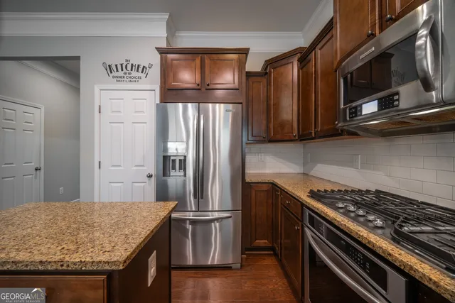 a kitchen with stainless steel appliances granite countertop a refrigerator stove top oven and sink