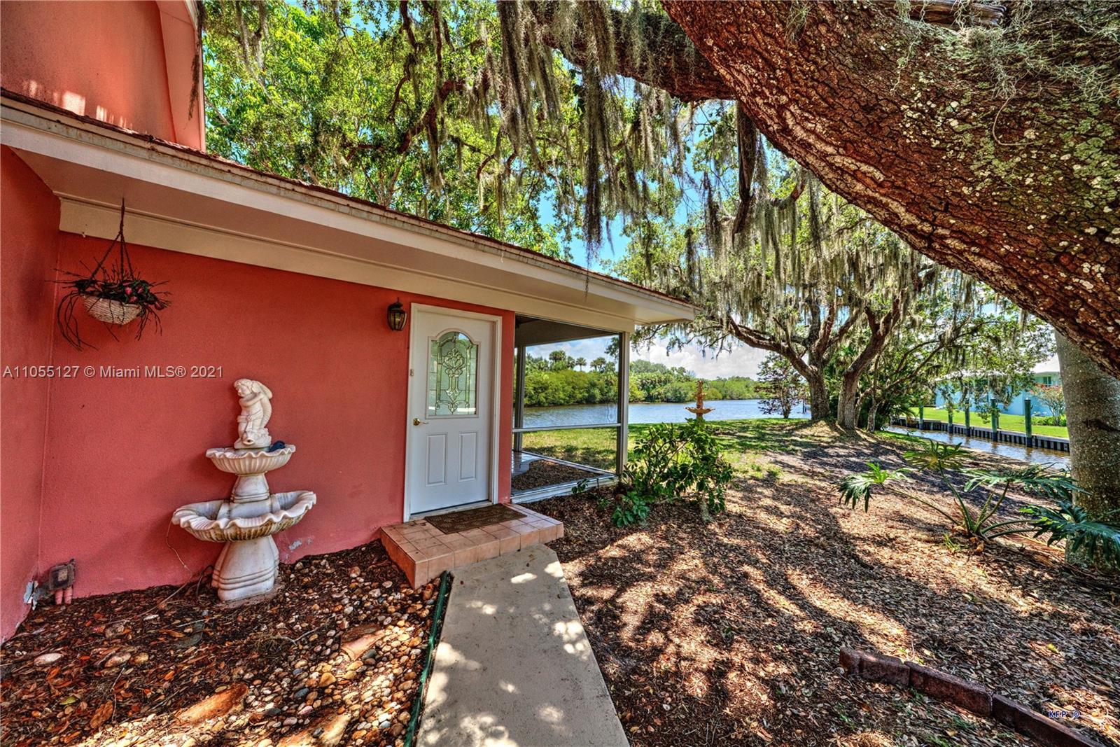 540 Southwest Salerno Road Stuart, FL 34997 - Photo 34 of 44 a backyard of a house with table and chairs under an umbrella