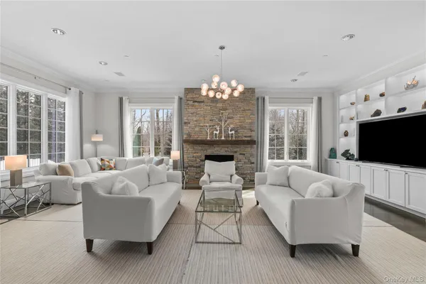 a living room with furniture a flat screen tv and a large window