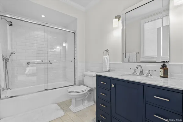 a bathroom with a granite countertop sink a toilet and shower
