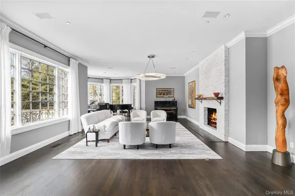 a living room with furniture large window and wooden floor