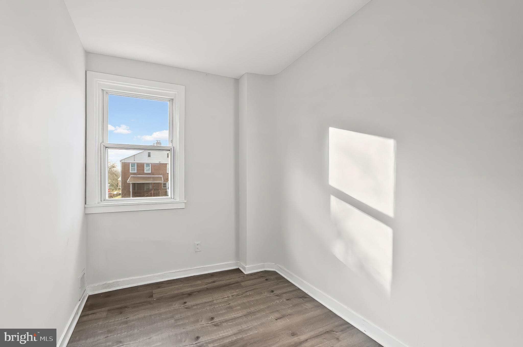30 North Athol Avenue Baltimore, MD 21229 - Photo 13 of 20 a view of an empty room with wooden floor and a window