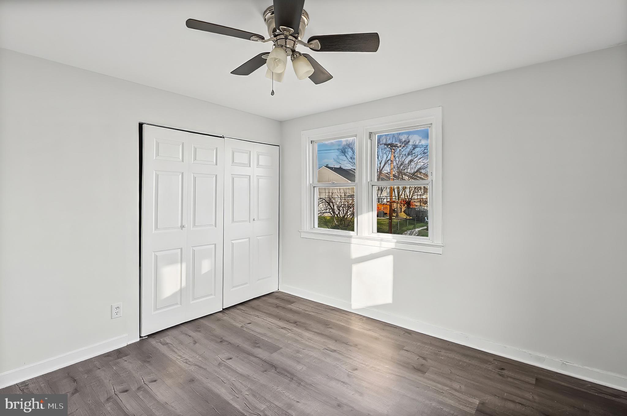 30 North Athol Avenue Baltimore, MD 21229 - Photo 10 of 20 an empty room with wooden floor chandelier fan and windows
