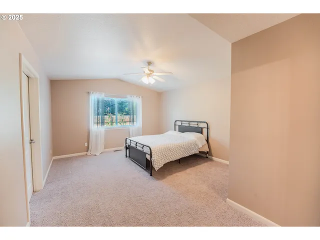 a spacious bedroom with a bed and a window