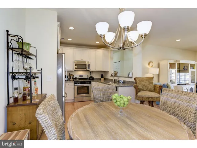 a living room with furniture kitchen view and a chandelier