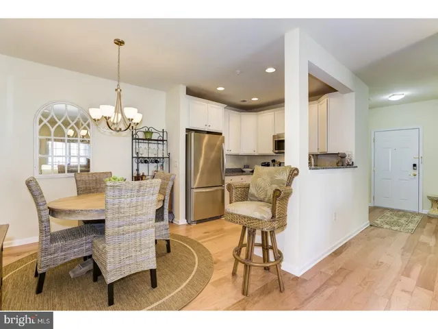 a dining room filled with furniture and kitchen view