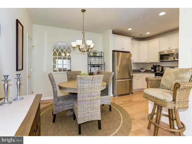 a kitchen with refrigerator cabinets dining table and chairs