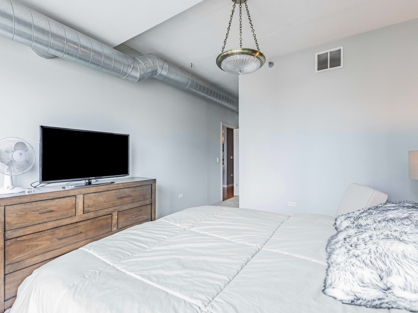 909 West Washington Boulevard, Unit 911 Chicago, IL 60607 - Photo 16 of 26 a bedroom with a bed and a flat screen tv