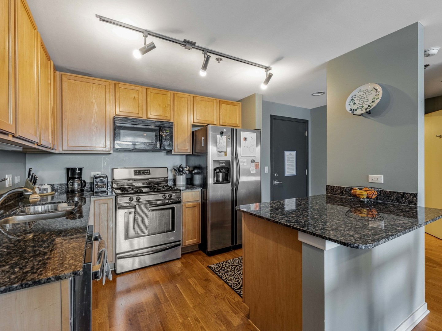909 West Washington Boulevard, Unit 911 Chicago, IL 60607 - Photo 8 of 26 a kitchen with stainless steel appliances granite countertop a sink a stove and a refrigerator