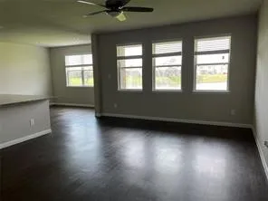 an empty room with wooden floor and windows
