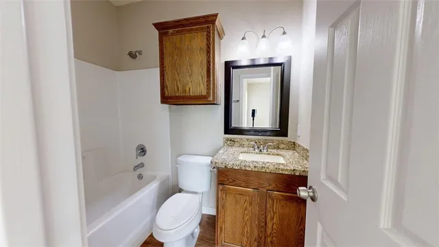 a bathroom with a granite countertop sink toilet and shower