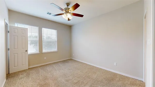 an empty room with closet and a chandelier fan