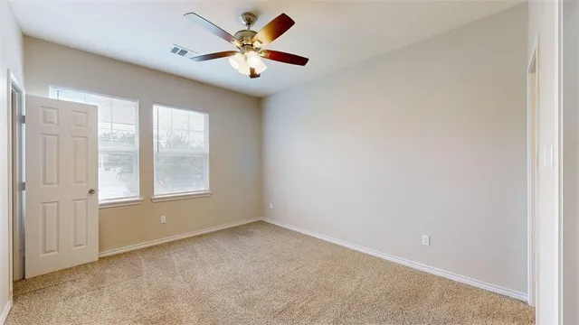 an empty room with closet and a chandelier fan