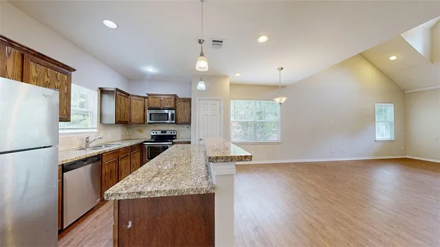 a view of a kitchen with a sink cabinets and wooden floor