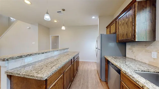 a kitchen with stainless steel appliances granite countertop a stove microwave sink and refrigerator