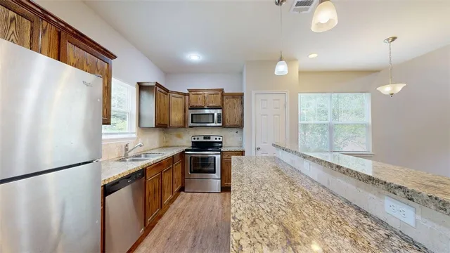 a kitchen with granite countertop a sink and a refrigerator