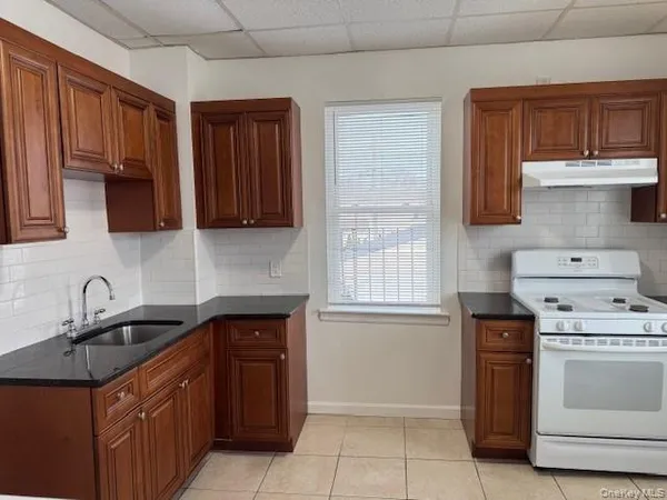 a kitchen with stainless steel appliances granite countertop a sink stove and microwave