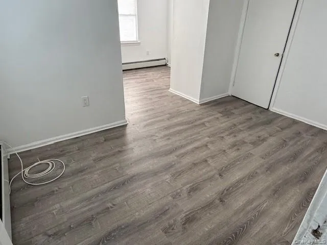 an empty room with wooden floor and mirror