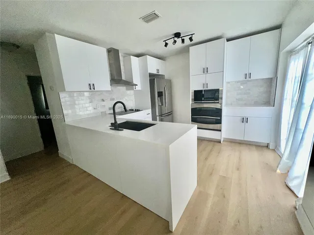 a kitchen with stainless steel appliances a sink stove and refrigerator