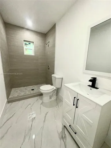 a bathroom with a sink mirror toilet and shower