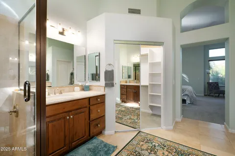 a spacious bathroom with a shower a sink and a mirror