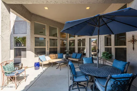 a view of a patio with a dining table and chairs under an umbrella