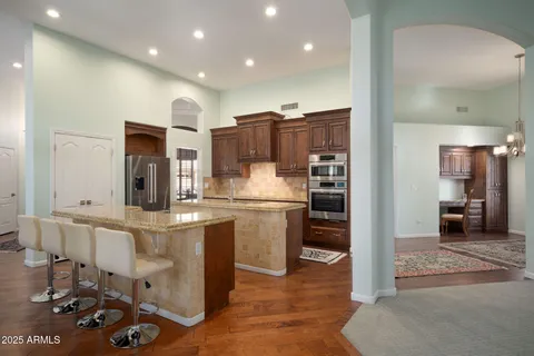 a kitchen with stainless steel appliances kitchen island granite countertop a refrigerator and stove