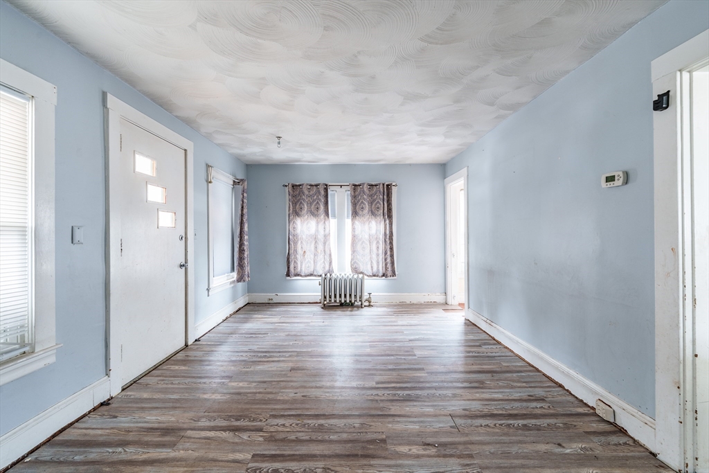 245 Arthur Street Springfield, MA 01104 - Photo 6 of 20 a view of an empty room with wooden floor and a window