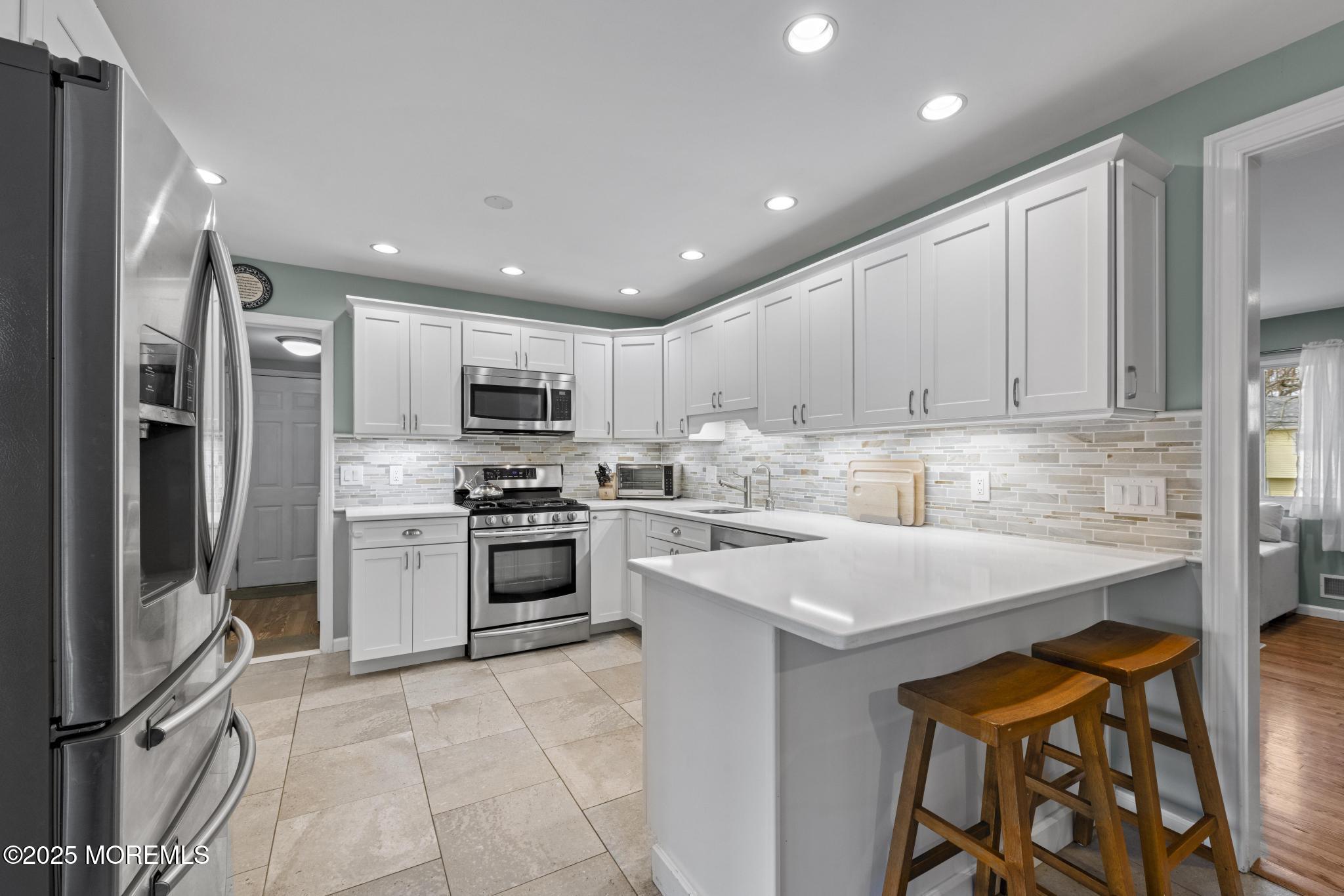 1704 Grove Street Wall, NJ 07719 - Photo 9 of 53 a kitchen with stainless steel appliances granite countertop a stove top oven a sink and a refrigerator