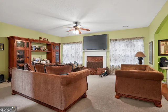 a living room with fireplace furniture and a flat screen tv