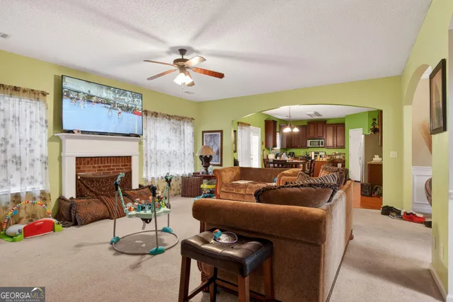a living room with furniture a fireplace and a chandelier