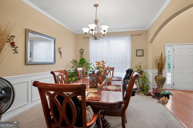 a view of a dining room with furniture and chandelier