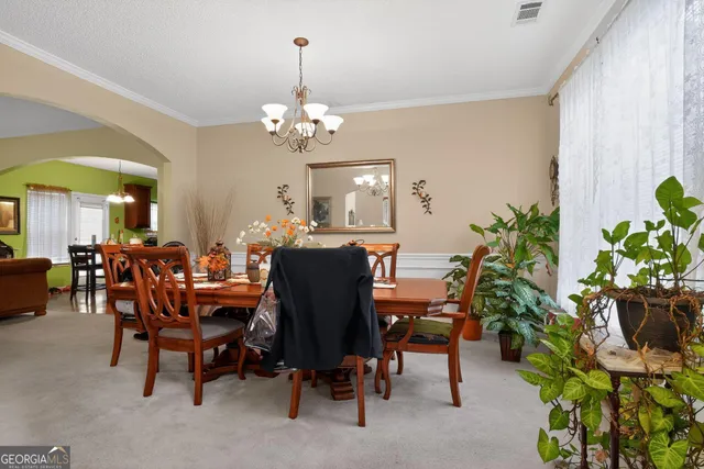 a view of a dining room with furniture and a chandelier