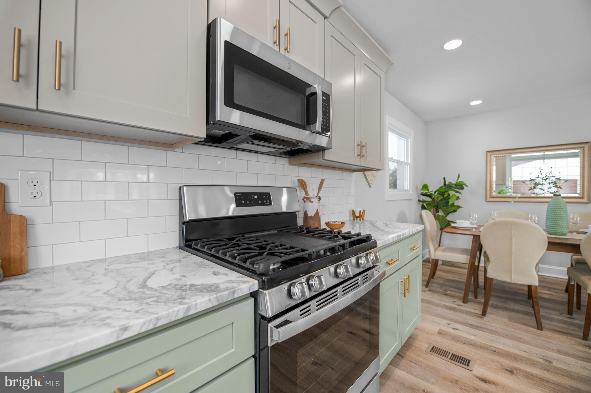 356 Abrams Mill Road King of Prussia, PA 19406 - Photo 6 of 46 a kitchen with stainless steel appliances granite countertop a stove a microwave a sink and cabinets