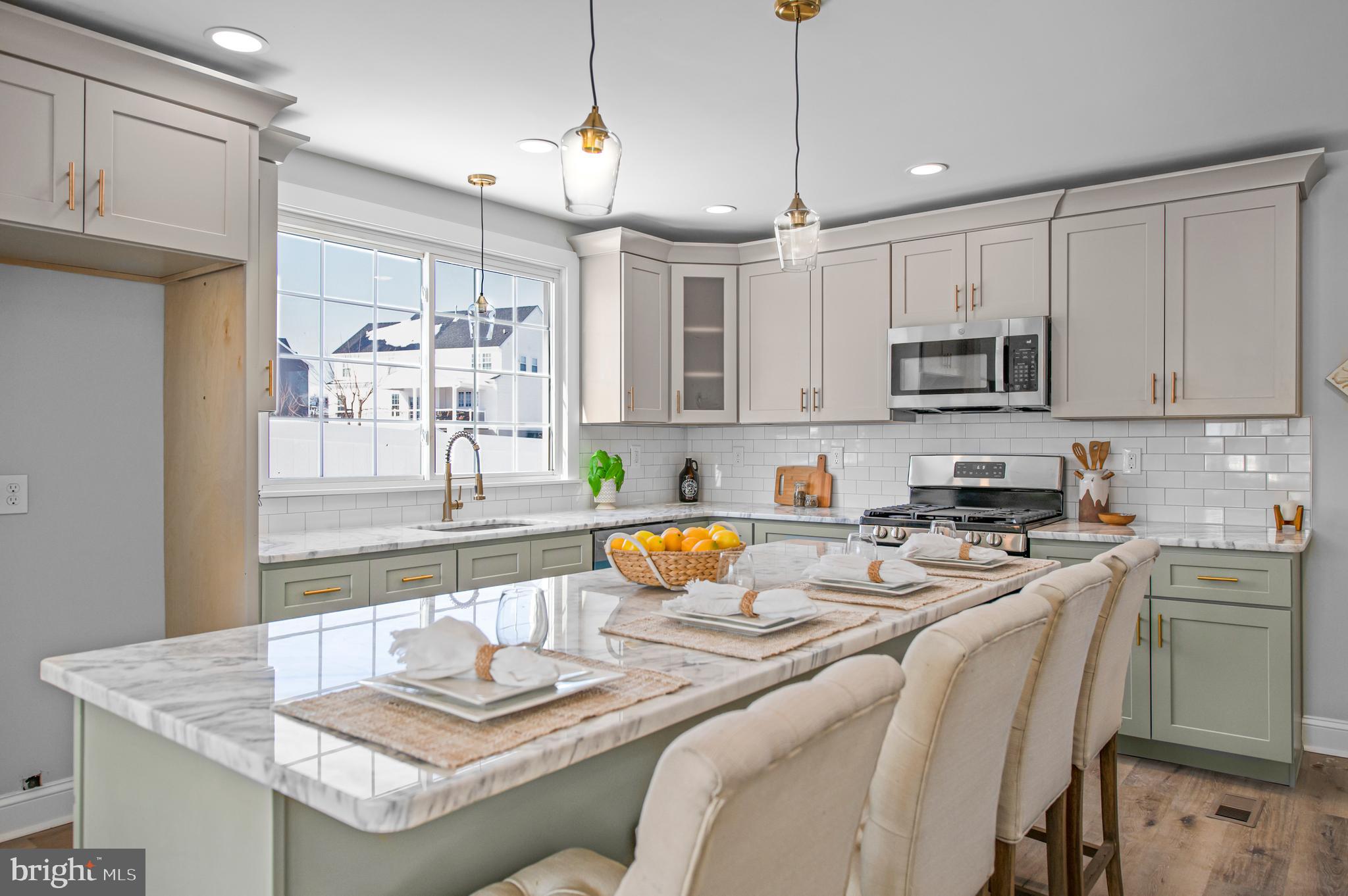 356 Abrams Mill Road King of Prussia, PA 19406 - Photo 7 of 46 a kitchen with stainless steel appliances granite countertop a refrigerator a sink a stove a dining table and chairs with wooden floor
