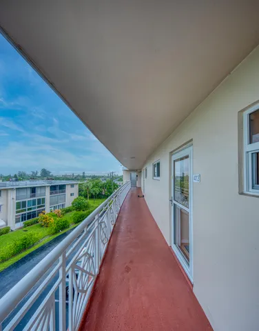 a living room with furniture a large window and a wooden floor