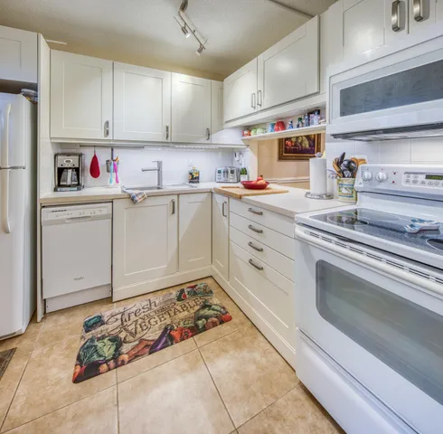 a kitchen with granite countertop a sink stainless steel appliances and cabinets