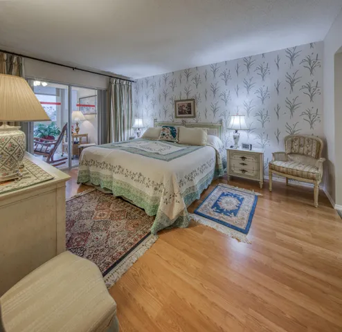 a spacious bedroom with a bed and wooden floor