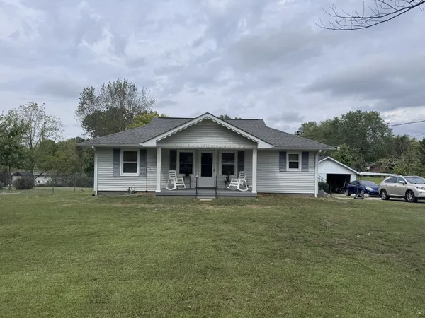 a front view of a house with a garden and yard