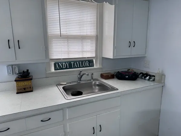 a kitchen with a sink a window and cabinets